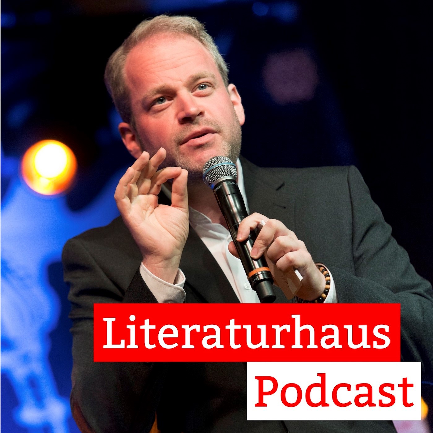 Foto von Sebastian Butte hinter dem Schriftzug des Literaturhaus-Podcasts
