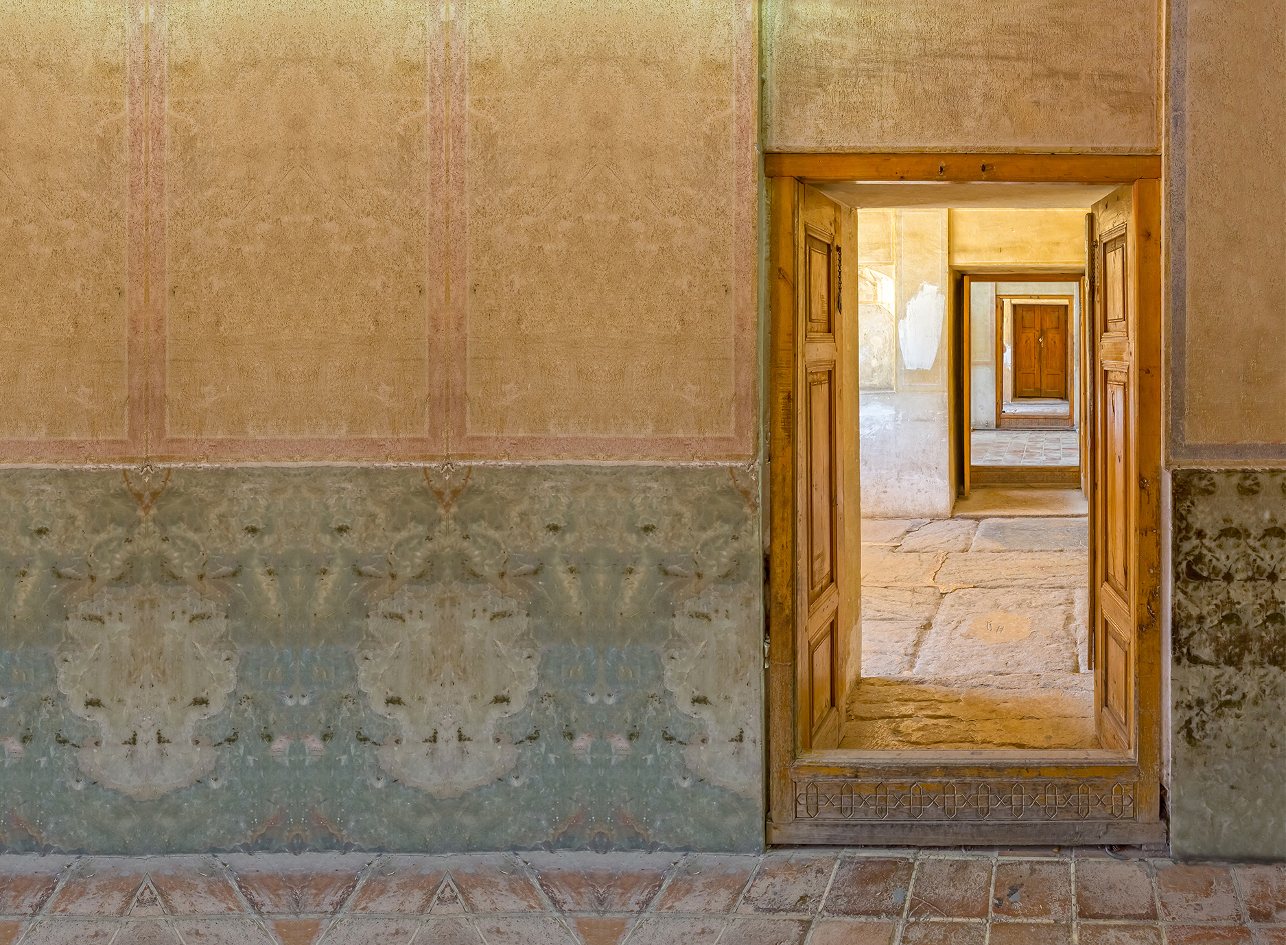 Foto einer geöffneten Tür, die in weitere offene Räume führt in persischer Architektur