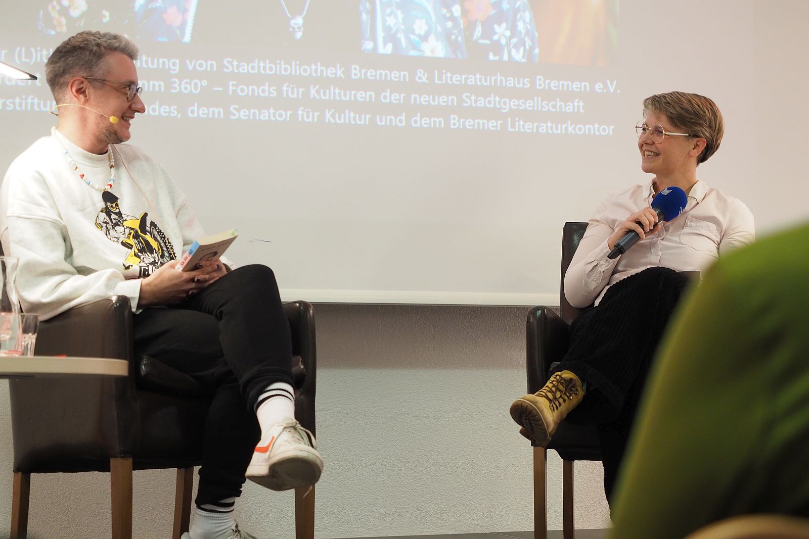 Linus Giese redet mit Katharina Guleikoff bei der Lesung