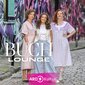 Drei Frauen stehen vor einer bunten Wand.