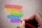 Hand schreibt Rauschen in Regenbogenfarben